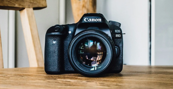 Canon DSLR camera on brown wooden table during daytime